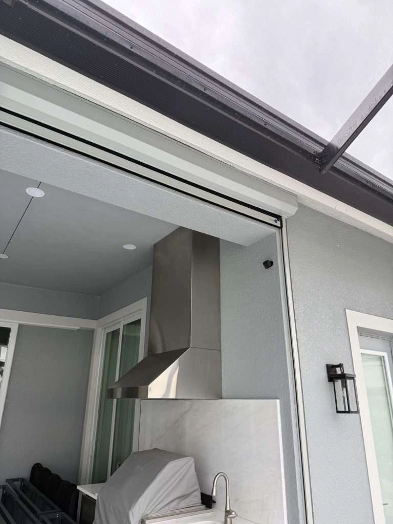 Close-up of a sleek, flush-mounted hurricane screen hood and side-retention track installed on a lanai in Naples, Florida.