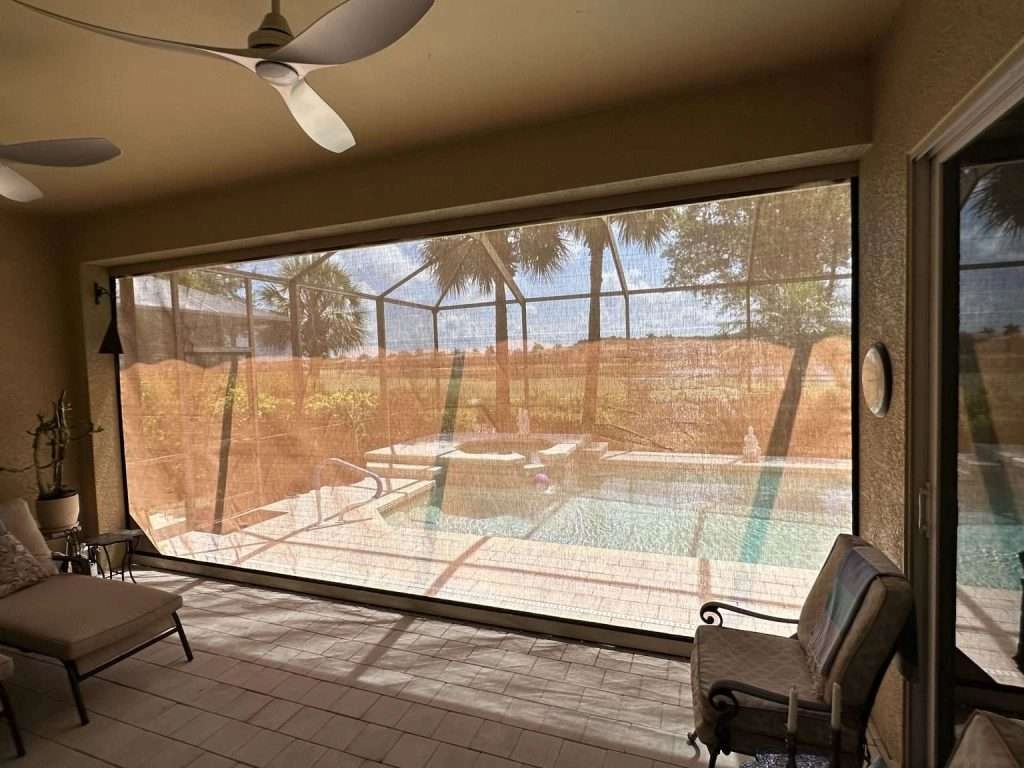 Motorized hurricane screens enclosing a lanai and pool area in Naples, Florida.